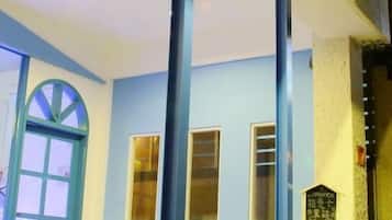 A room with a blue wall, a large window, and a door. There is a sign with text on the wall.