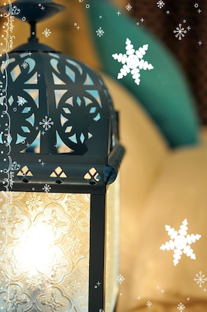 A close-up of a black lantern with intricate cut-out patterns and a warm light source. - Lamanca B&B (Hualien City)