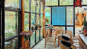 A spacious room with large windows, a high ceiling, and a rustic wooden ceiling. - Trai Hoa Vang Homestay - Hostel (Phu Yen)