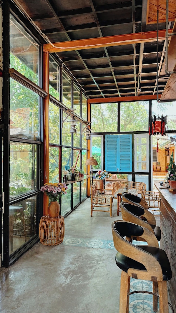 A spacious room with large windows, a high ceiling, and a rustic wooden ceiling. - Trai Hoa Vang Homestay - Hostel (Phu Yen)