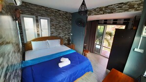Un dormitorio con cama, ventilador, ventana y vistas al exterior.