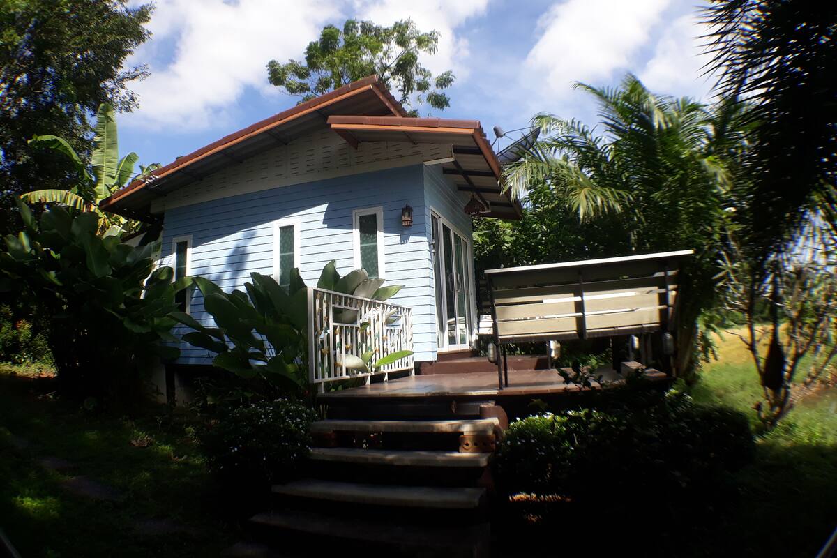 A house with a porch, steps, and a bench.