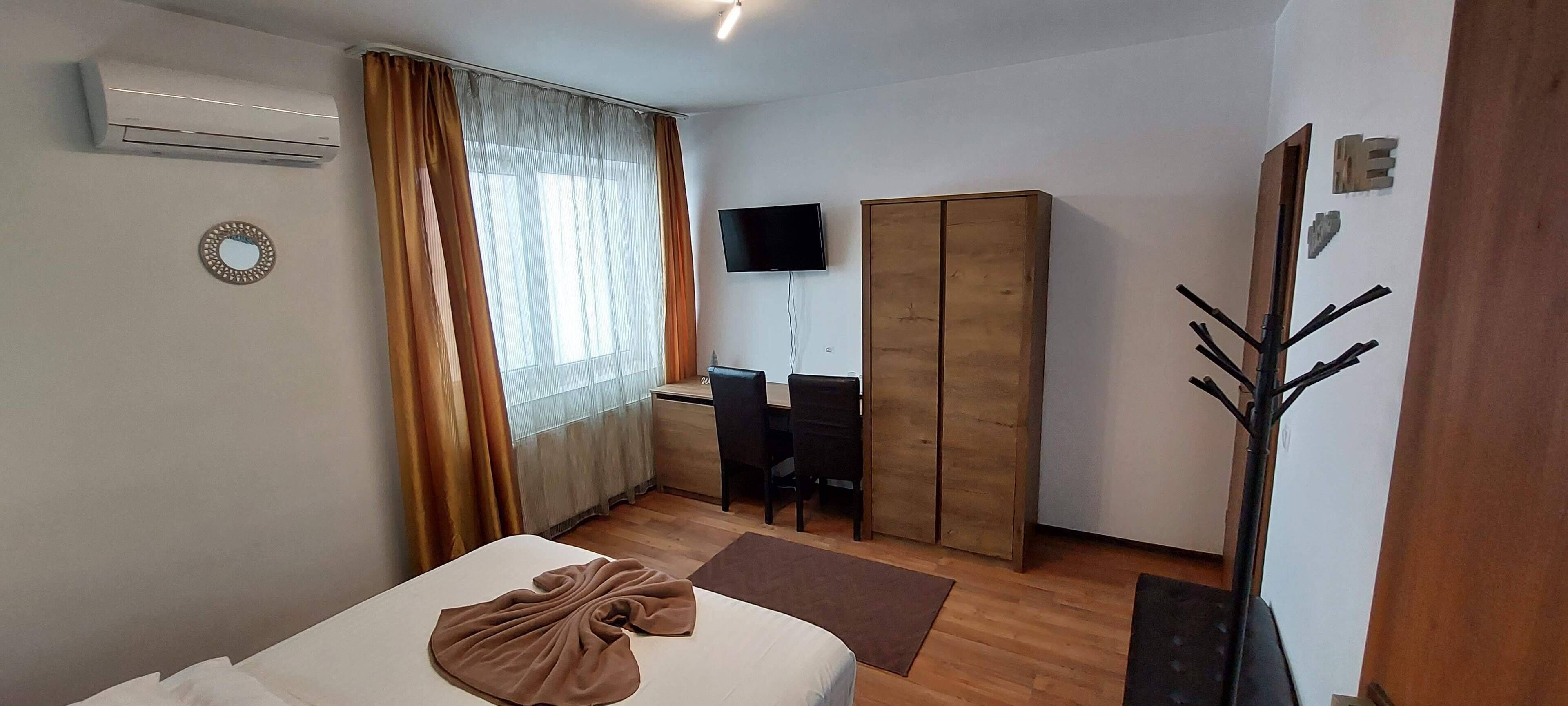 Une chambre d’hôtel équipée d’un lit, d’un bureau, d’une armoire, d’une télévision et de la climatisation.