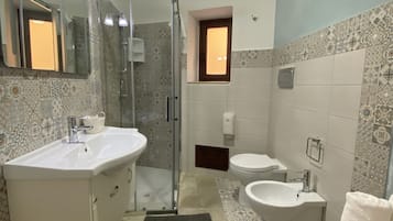 Chambre Triple Confort, vue ville | Salle de bain | Douche, articles de toilette gratuits, sèche-cheveux, bidet