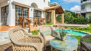 Una piscina al aire libre, sillones reclinables de piscina