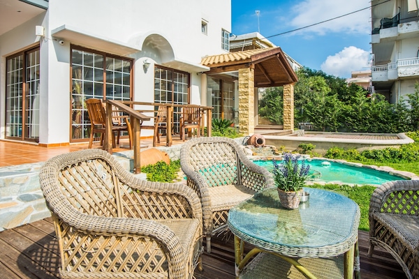 Una piscina al aire libre, sillones reclinables de piscina