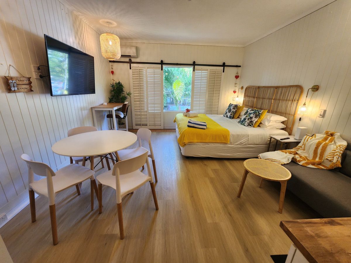 Ein gemütliches Schlafzimmer mit Bett, Nachttisch und einem Fenster mit Rollläden.
