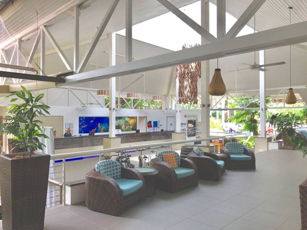A spacious indoor area with wicker furniture and a reception desk.