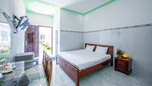 A bedroom with a bed, bedside table, and a small table with chairs.