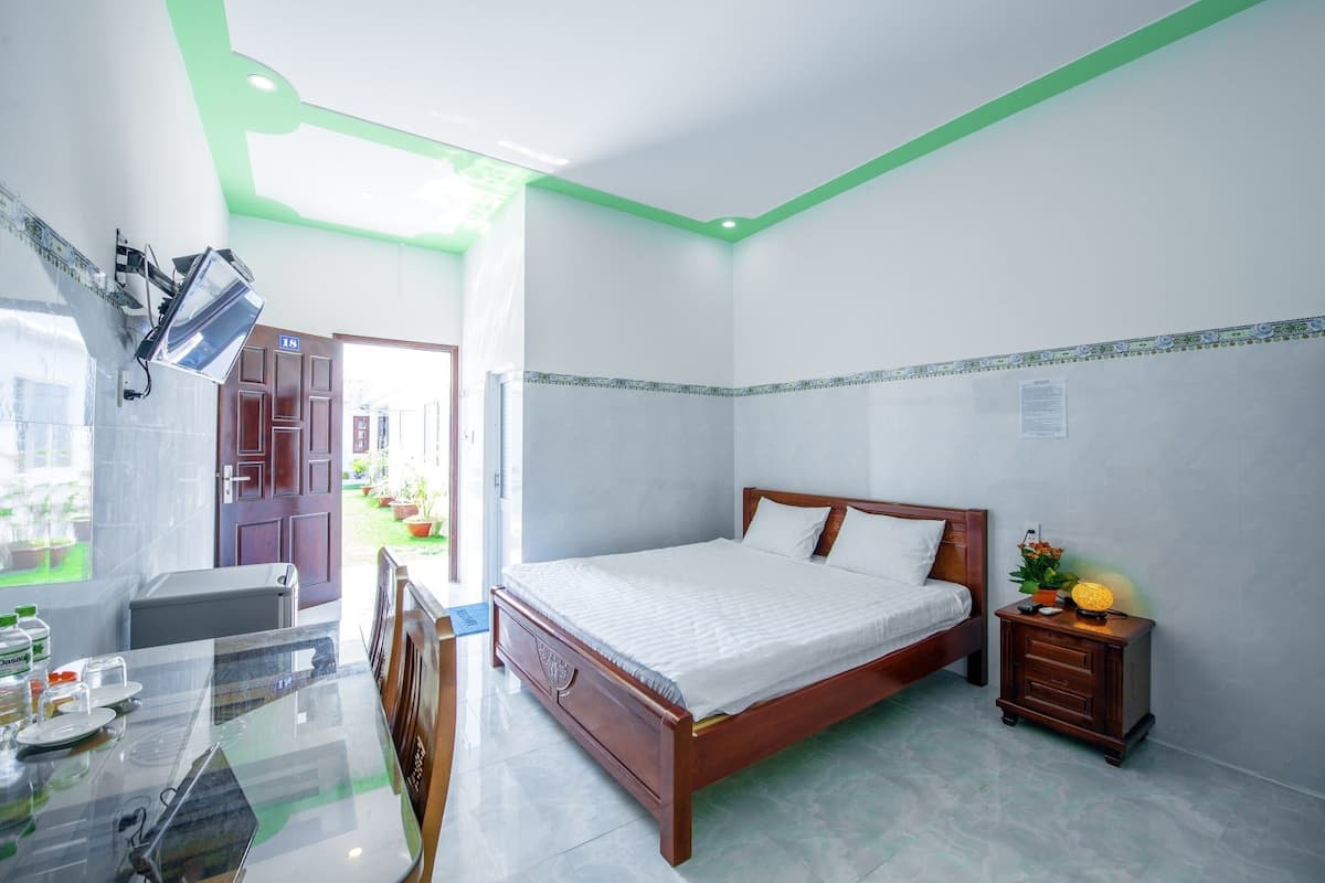A bedroom with a bed, bedside table, and a small table with chairs.