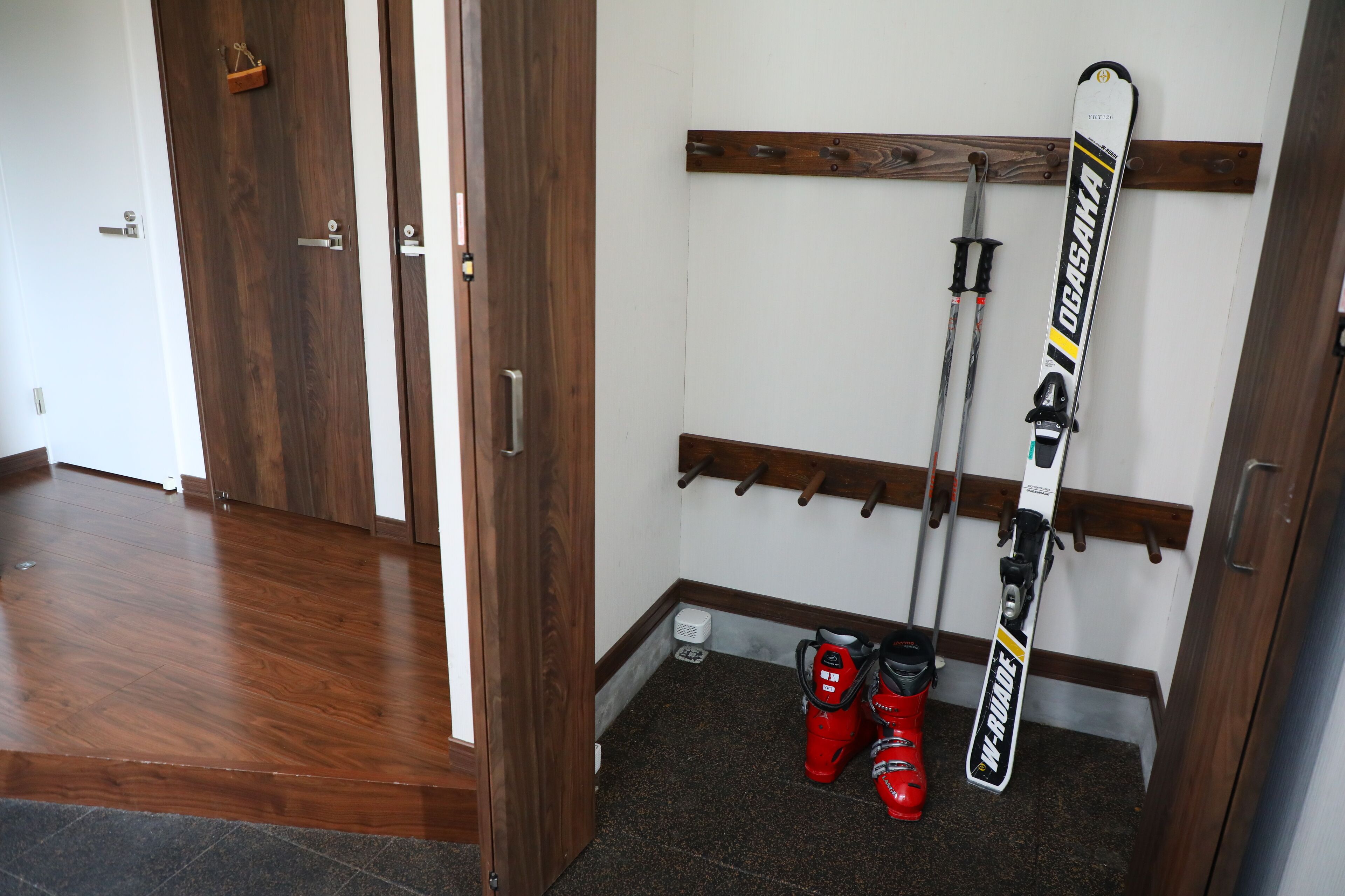 Un espace de rangement pour les skis, comprenant des skis et des chaussures de ski.
