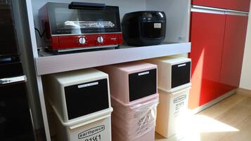 A kitchen area with a microwave, toaster, and plastic containers labeled "earthpiece" on a shelf.