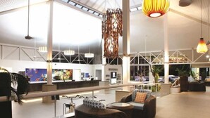 A spacious lobby with high ceilings, modern furniture, and a reception desk. - C215 Ramada Resort Deluxe King - Free Wifi (Port Douglas)