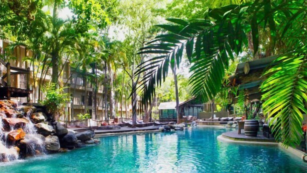 A pool surrounded by lush greenery and a waterfall. - C215 Ramada Resort Deluxe King - Free Wifi (Port Douglas)