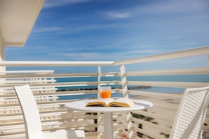 A white outdoor seating area with a table, a chair, and an open book. - Baldinini Hotel (Rimini)