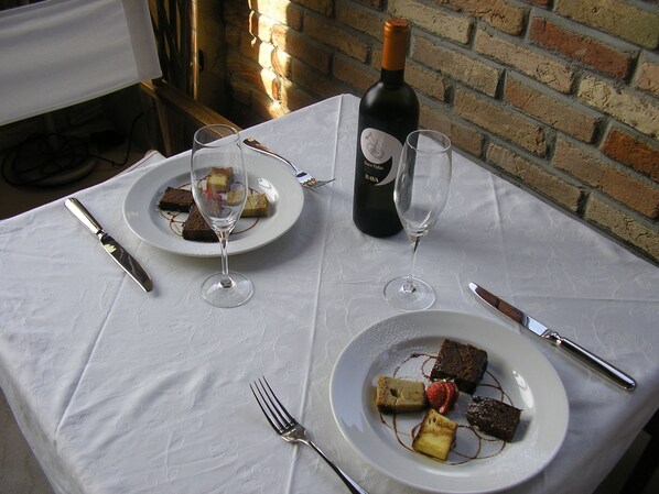 A table set with plates of dessert, wine glasses, and cutlery. - Ca' Villa Club Agriturismo (Gabiano)