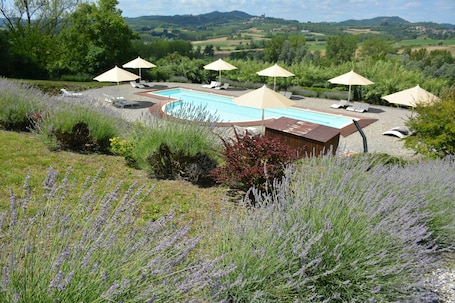 Una piscina al aire libre, sillones reclinables de piscina