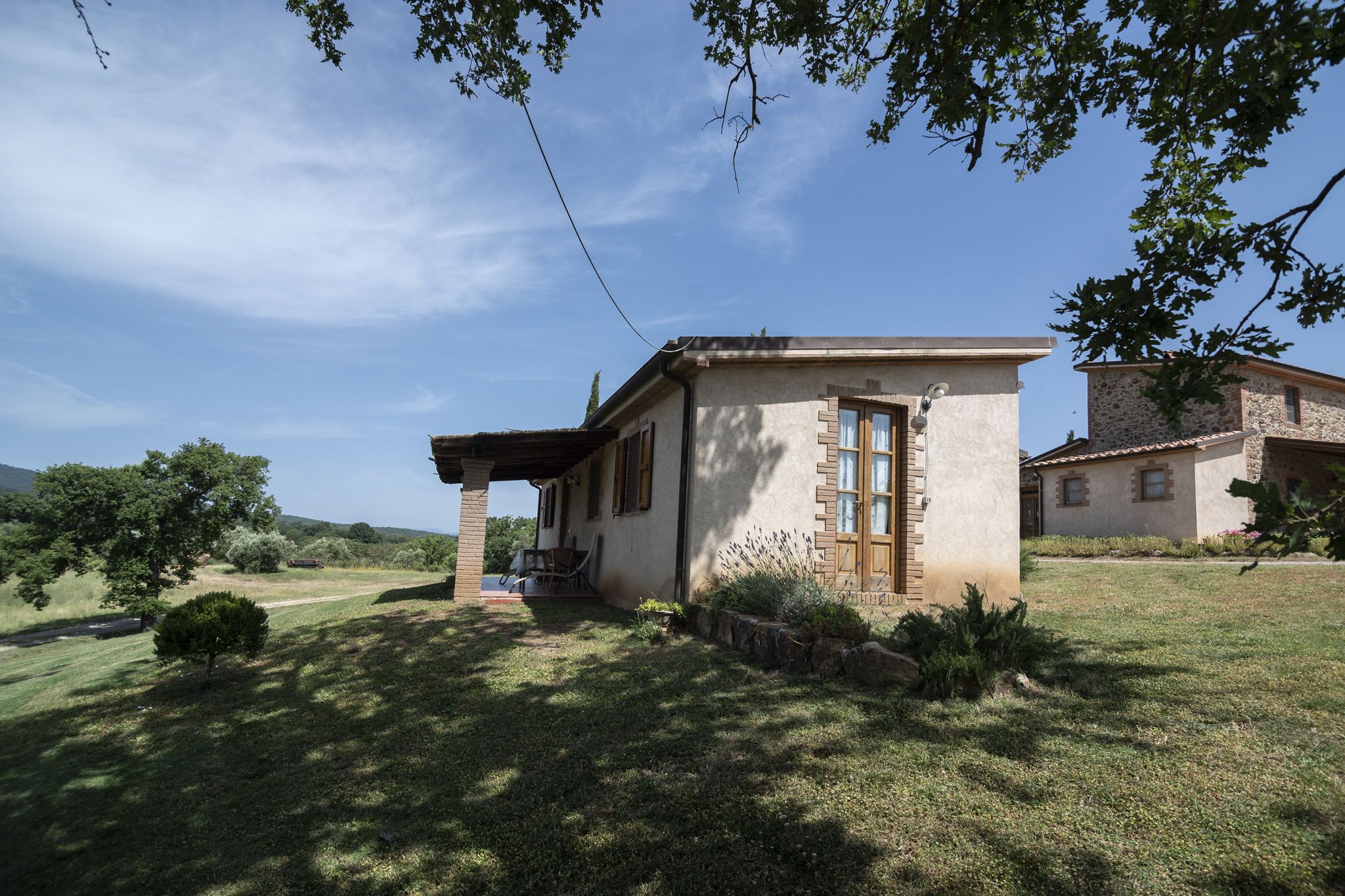 Ein kleines, eingeschossiges Haus mit Steinaußenwand, einer Holztür und einer kleinen Veranda.