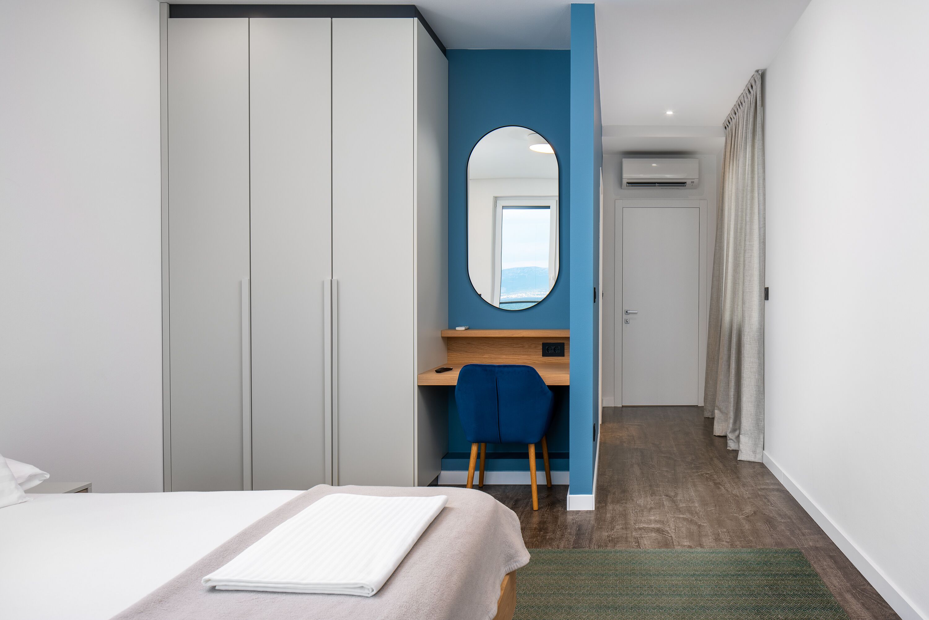 Een slaapkamer met een bed, een bureau en een kledingkast.