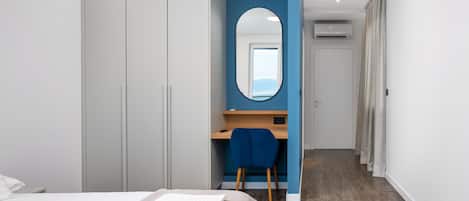 Een slaapkamer met een bed, een bureau en een kledingkast.