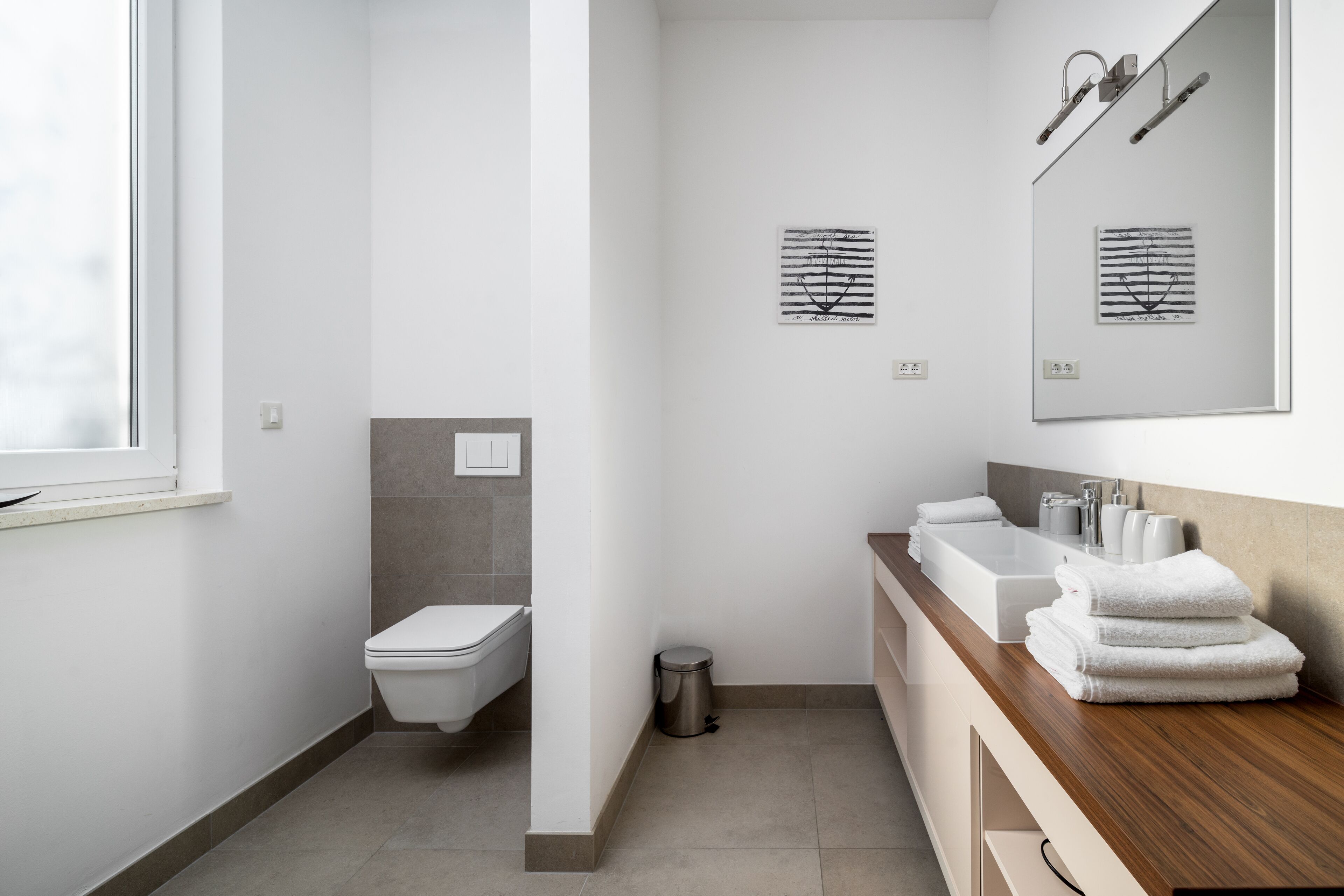 A modern bathroom with a toilet, sink, and mirror.