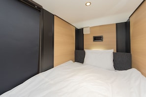 Ein Hotelzimmer mit einem Bett, dunklen Wänden und einer Wand aus Holz.