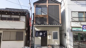 A traditional Japanese building with a two-story structure, a sliding door, and a small porch area. - Ryoma Nishiooi I - Hostel (Tokyo)