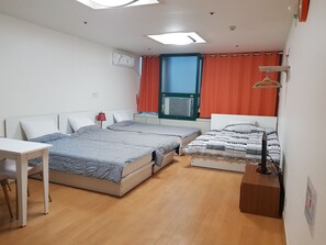 A room with two beds, a desk, and a window with curtains. - Seoul Stay (Seoul)
