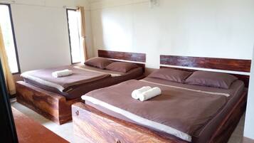 Two single beds with wooden headboards, brown bedding, and white towels.