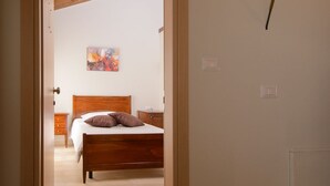 A bedroom with a wooden bed, a nightstand, and a painting on the wall.