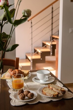 A breakfast setting with croissants, a glass of orange juice, a cup, and walnuts on a table. - La Dimora di Federico (Avigliano)
