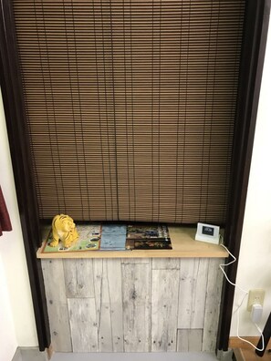 Ein Zimmer mit einer Holzhakpartition, einer kleinen Ablage mit einer Tigerfigur, einer Uhr und einer Karte.
