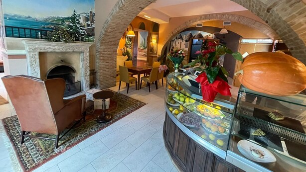 A hotel lobby with a fireplace, seating area, and a fruit display. - Hotel 99 Cannelle (L'Aquila)