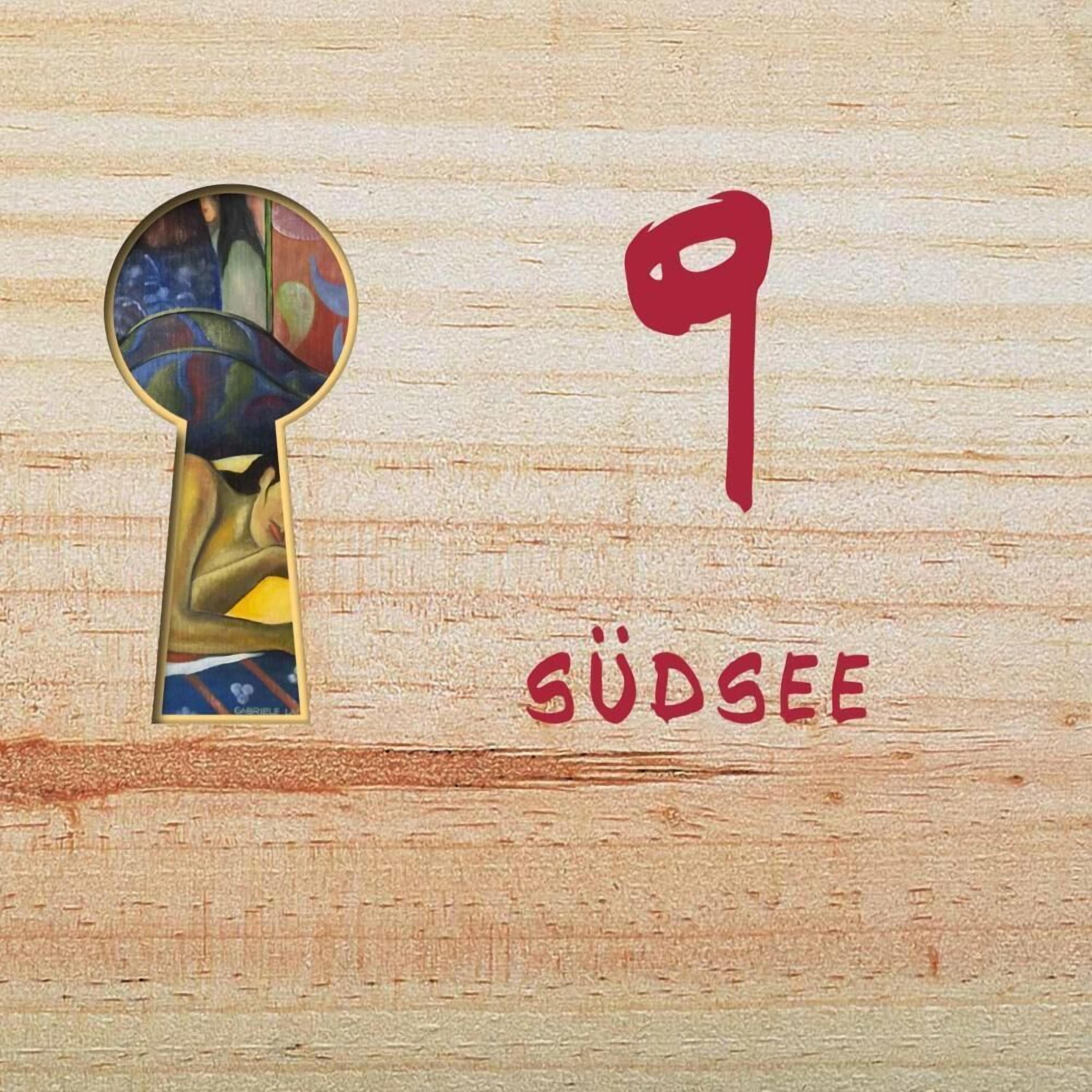 Ett nyckelhål med en färgstark design, siffran 9 och ordet ”GÜDSEE” mot en träbakgrund.