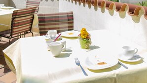 A table set outdoors with a view of a forested hill.