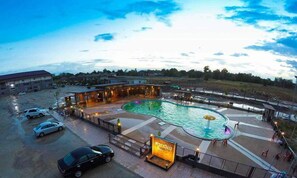 A swimming pool with a water fountain, surrounded by a covered area with seating and a sign indicating a restaurant. - Sukhothai Porncharoen Resort & Spa (Kong Krailat)