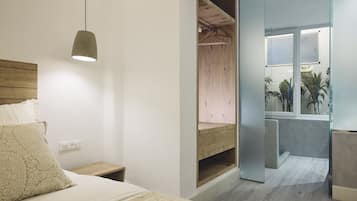 Un dormitorio con cama, mesita de noche y lámpara colgante.