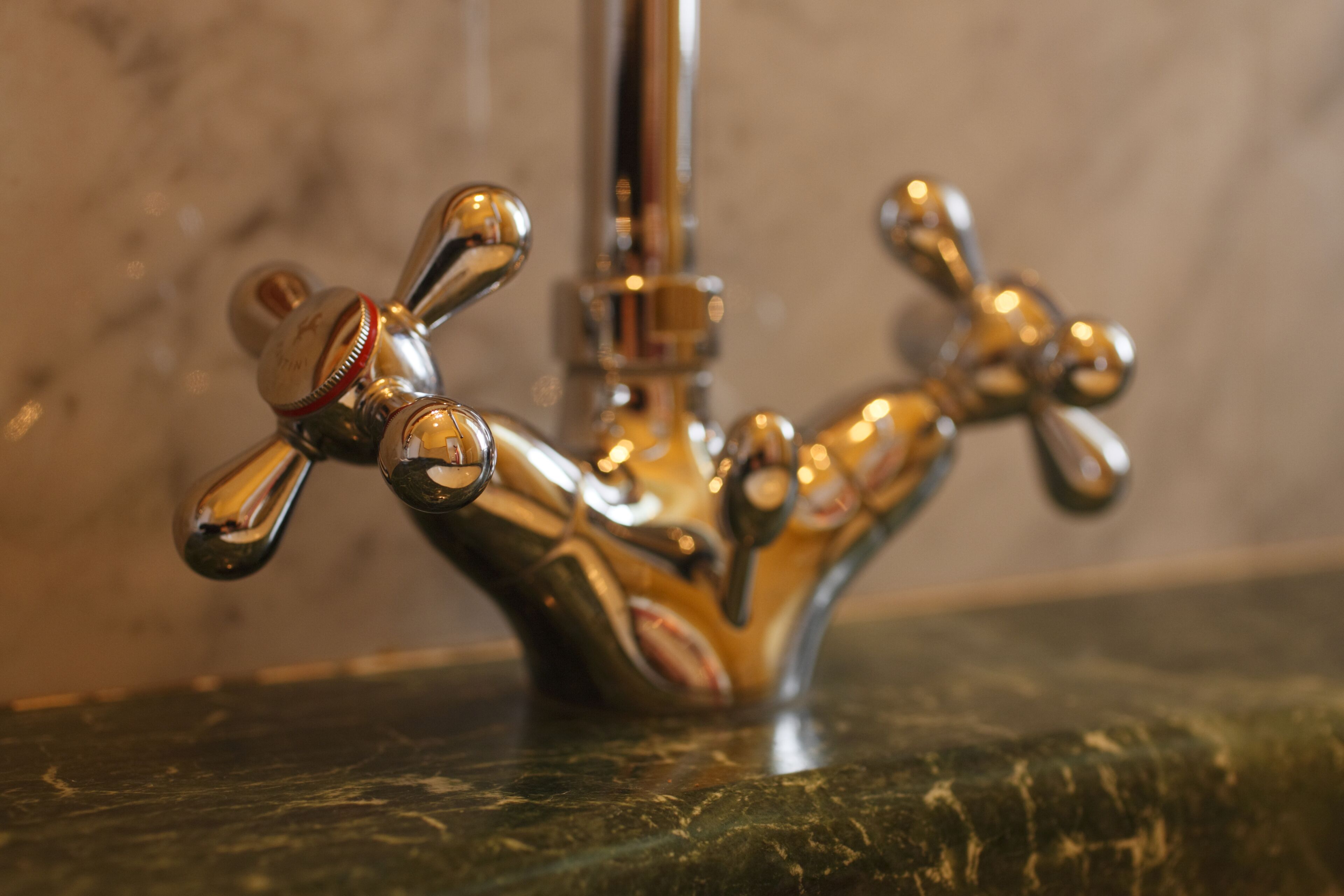 A bathroom with a unique, artistic faucet design.