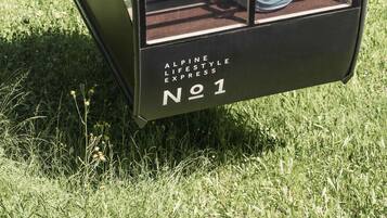 A glass-enclosed tram with the text "Alpine Lifestyle Express" and "No 1" visible.