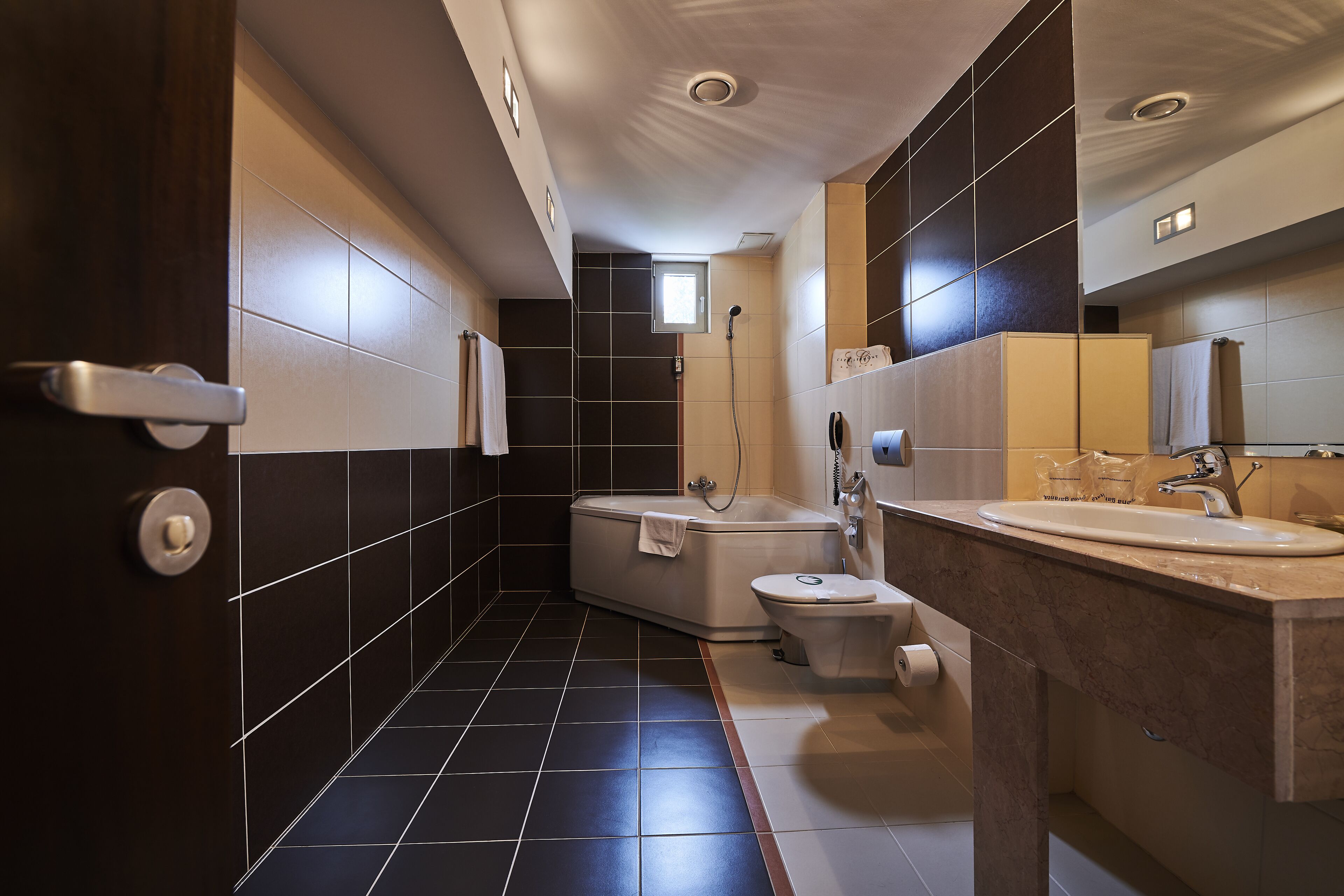 A modern bathroom with a bathtub, toilet, and sink.
