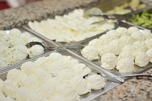 A buffet with various food items including cauliflower and other vegetables.