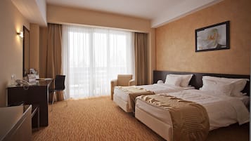 Una habitación de hotel con una cama grande, un escritorio con teléfono y una silla.