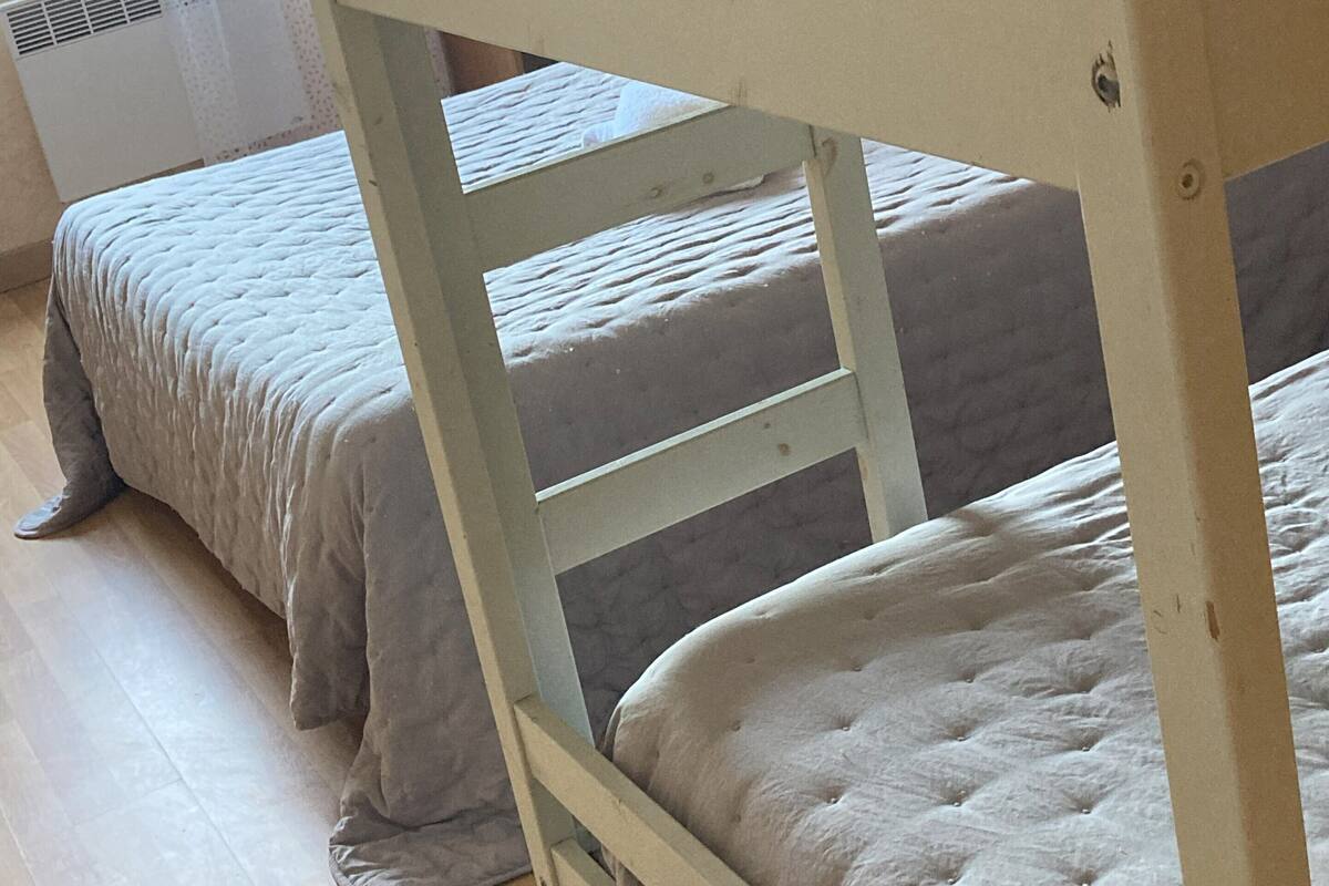 A bunk bed with a headboard and two lower beds.