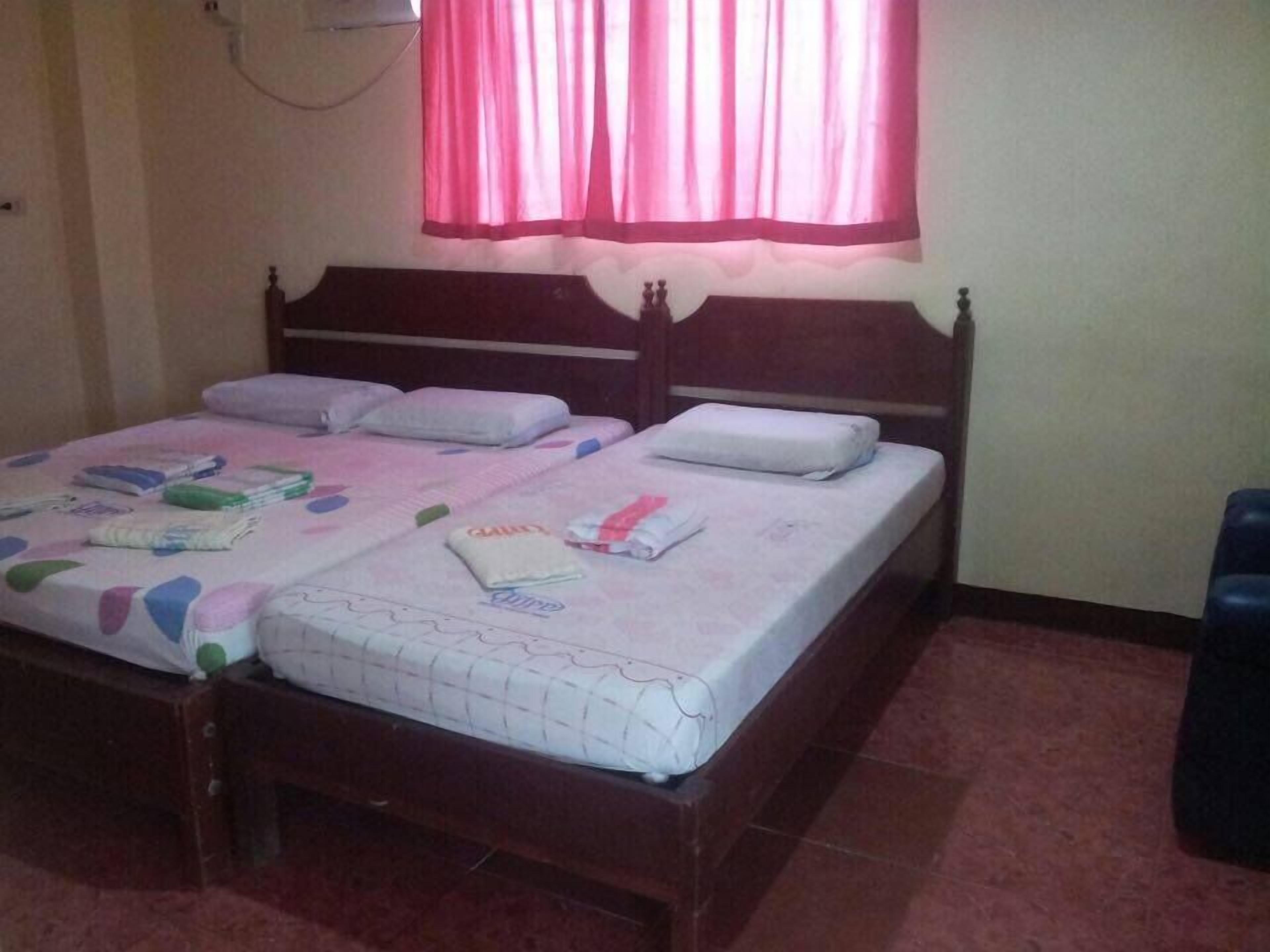 A bedroom with two beds, each with a headboard and pillows.