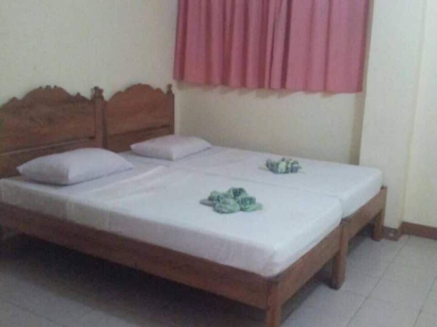 A single-bed room with a wooden headboard, white bedding, and a pink curtain.