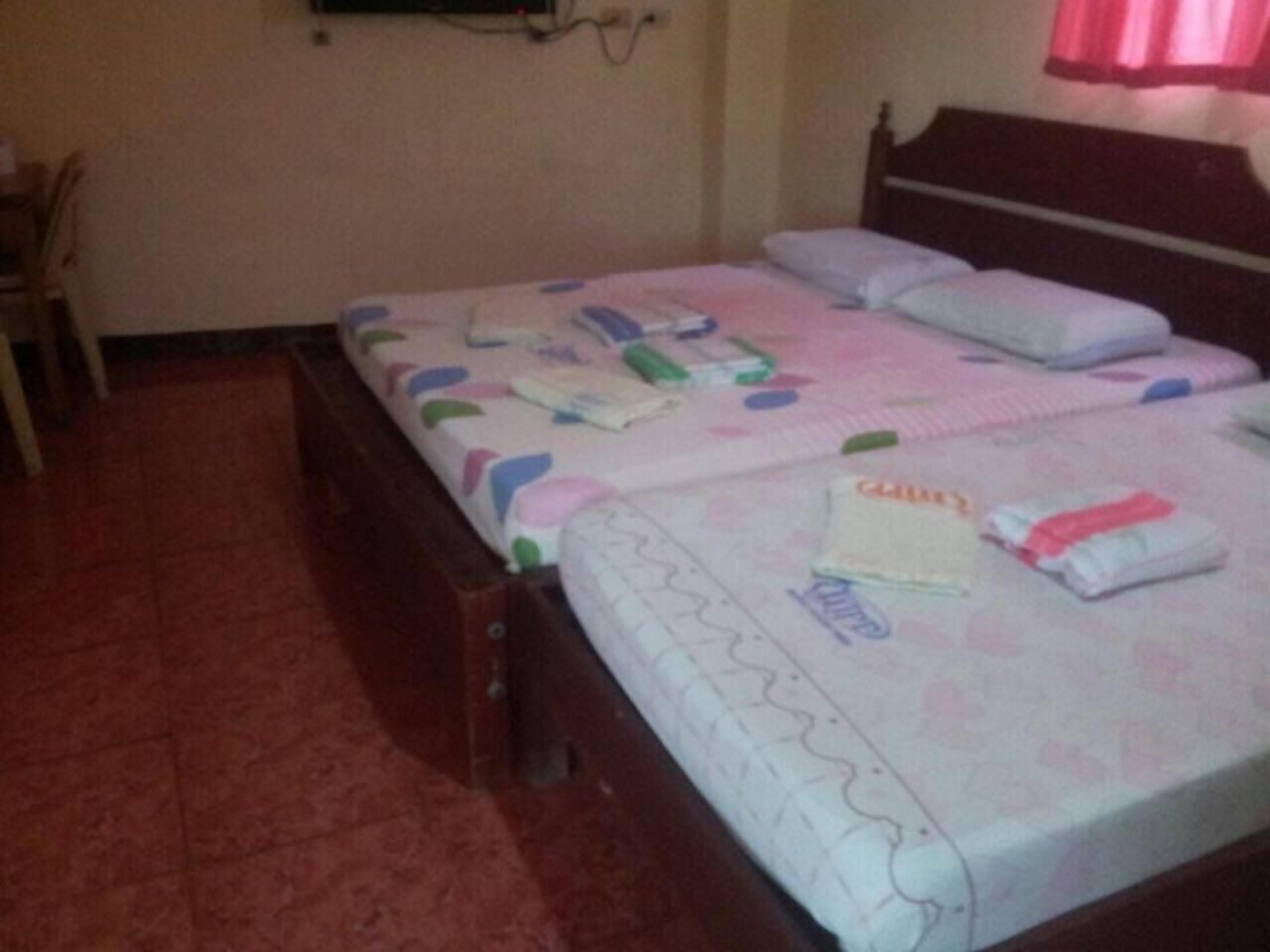 A bedroom with a bed, pillows, and a bedside table.