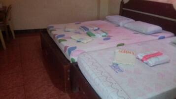 A bedroom with a bed, pillows, and a bedside table.