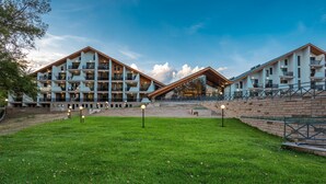A modern hotel with a central courtyard, multiple balconies, and a spacious outdoor area. - Park Hotel Asarel (Panagyurishte)