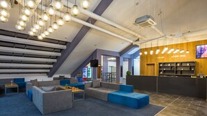 A modern lobby with a staircase, seating areas, a bar, and a TV screen. - Park Hotel Asarel (Panagyurishte)