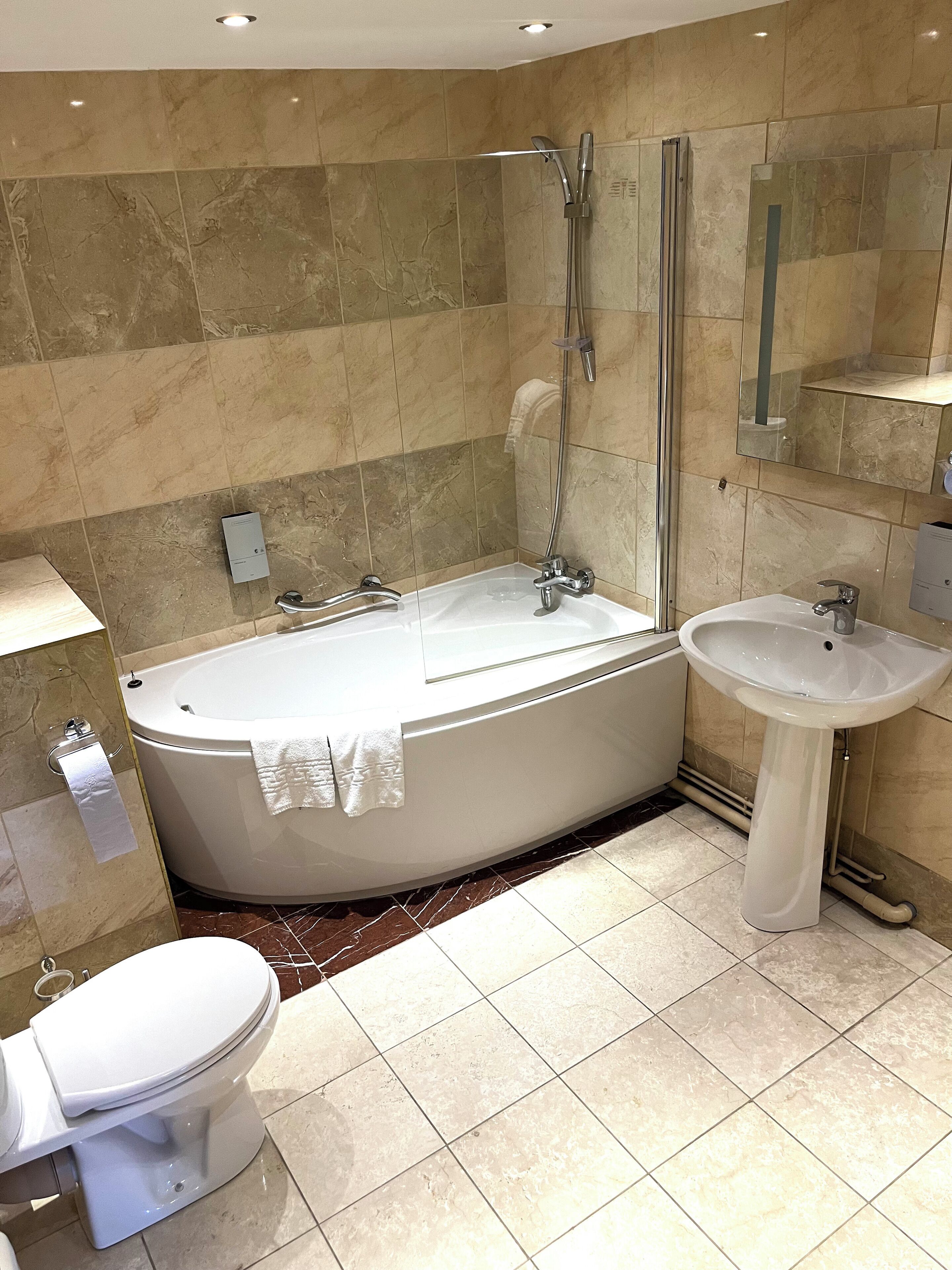 Un baño moderno con una bañera independiente, un lavamanos aparte y un inodoro.
